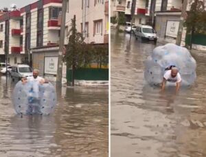 Sağanakta suyla dolan caddede içine girdiği büyük şeffaf balonla ilerledi